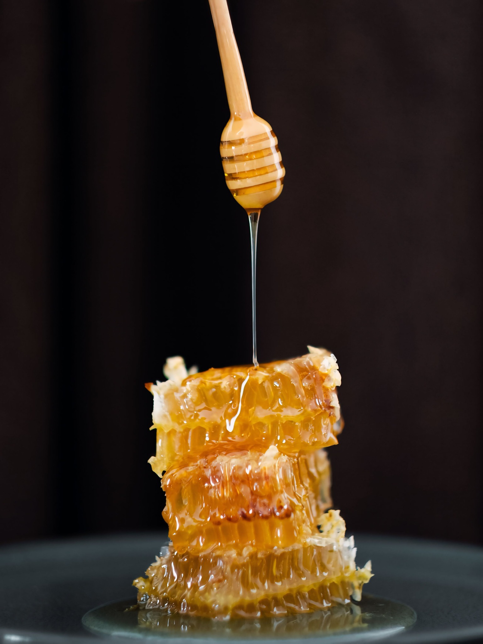 Pure honey dripping from honeycomb